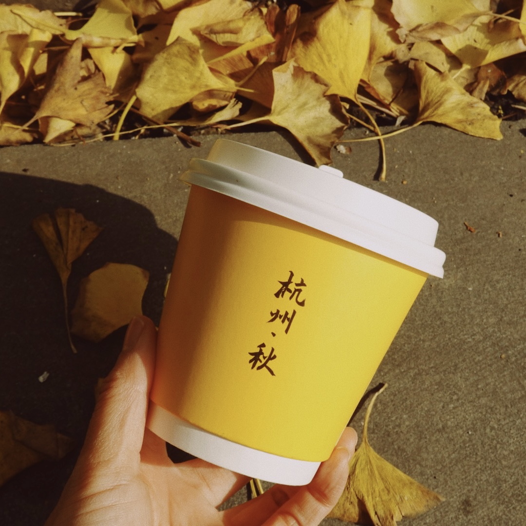 杭州秋天银杏叶旁的咖啡杯